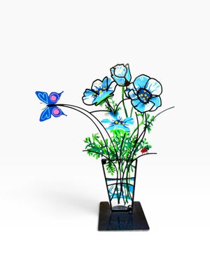 un vase en verre orné de fleurs bleues et d'un papillon