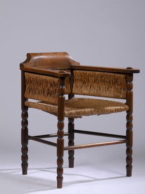 une vieille chaise en bois avec une assise en cuir et des pieds en bois