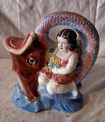une figurine représentant une fillette assise sur un cheval