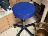 a blue stool sitting on the floor in front of a cardboard box