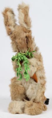 un petit lapin en peluche avec une carotte dans la bouche