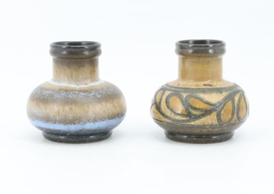 two vases sitting side by side on a white surface