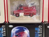 three boxed toys of a red fire truck in a display case