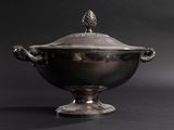 an antique silver plated bowl with a lid on a black background