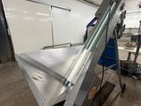 a machine that is moving a sheet of metal on a conveyor belt