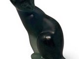 a black cat statue sitting on a white surface