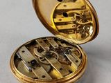 an image of a gold pocket watch sitting on top of a table