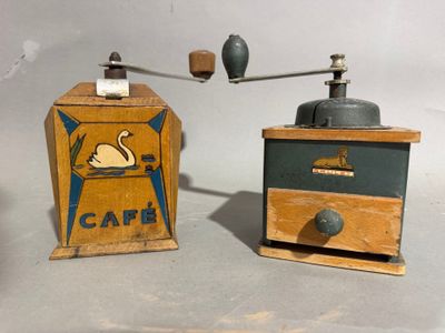 two old fashioned coffee grinders sitting on a table