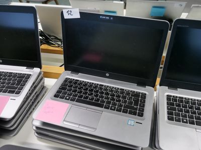 Plusieurs ordinateurs portables sont alignés sur une table dans un magasin