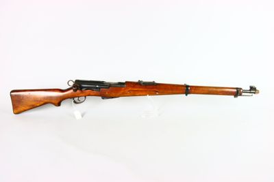 un fusil avec un canon en bois sur fond blanc