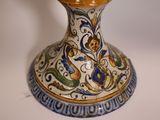 a blue and yellow vase sitting on a white table