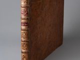 un vieux livre à la couverture brune posé sur une table