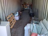 a room with a couch and a bed inside of a shipping container