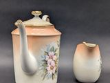 two vases and a teapot sitting next to each other
