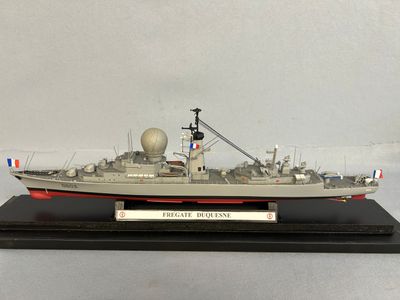 the model of a battleship is on display on a black stand