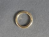 gros plan d'une bague en or sur une surface grise