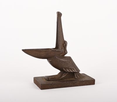 une statue en bronze représentant un pélican perché sur un socle en bois