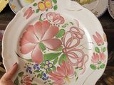 a person holding a plate in front of a bunch of plates