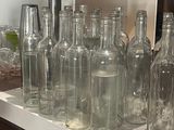many empty glass bottles on a counter in a kitchen