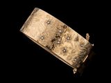 une image représentant un bracelet en or serti de diamants sur fond noir