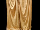 a gold curtain with a black background behind it
