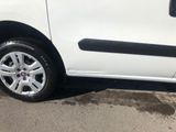 a small white van parked on the side of the road