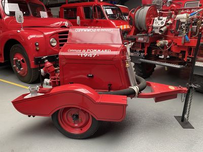 un camion de pompiers rouge garé à côté d'autres camions de pompiers