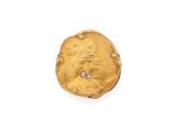 une vieille pièce d'or posée sur une surface blanche, avec un diamant au centre