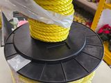 une bobine de corde jaune posée sur une bobine noire