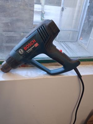 un sèche-cheveux filaire posé sur le rebord d'une fenêtre