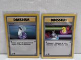 two pokemon cards sitting on top of each other on a table
