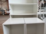 two white cabinets in the middle of a warehouse
