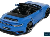 the blue porsche 911 gts is parked on a white surface