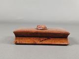a small wooden box with a ring on top of it