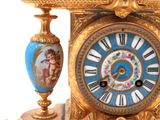 a gold clock with a blue and white design on it