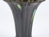 a black vase with a green and yellow design on it