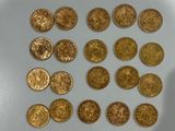 a close up of a pile of gold coins on a white surface