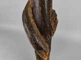 a close up of a sculpture of a person holding a tree branch