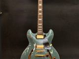une guitare électrique au corps vert posée sur un support