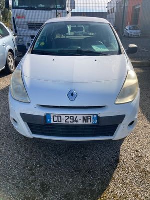 the front of a white car parked in a lot next to other cars