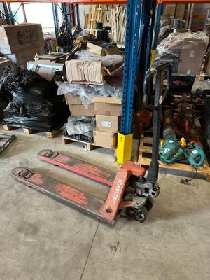 a forklift in a warehouse filled with boxes and other items