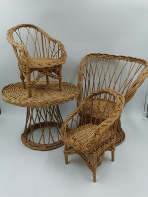 trois chaises en osier et une table sont disposées sur un fond blanc