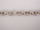 a close up of a silver chain on a white surface