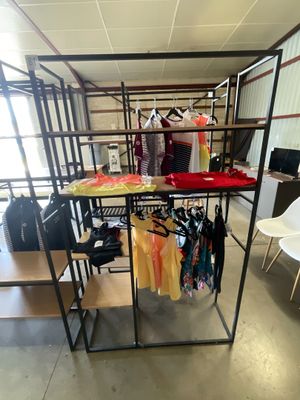 a room with a rack of clothes and a chair in it