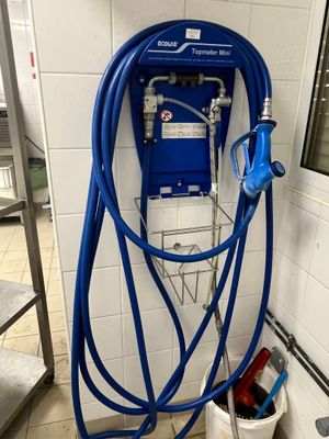 un tuyau bleu raccordé à une machine bleue dans une salle de bains