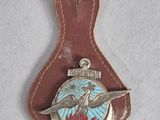 a close up of a leather keychain with a bird on it