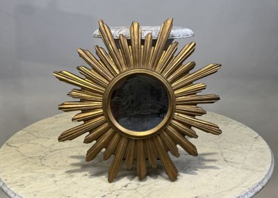 un soleil doré posé sur une table en marbre blanc