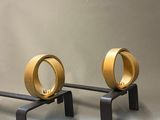 two gold rings sitting on top of a black bench