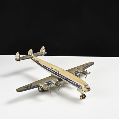 une vieille maquette d'avion posée sur une table blanche