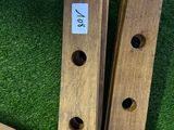 two pieces of wood with holes in them sitting on a green surface